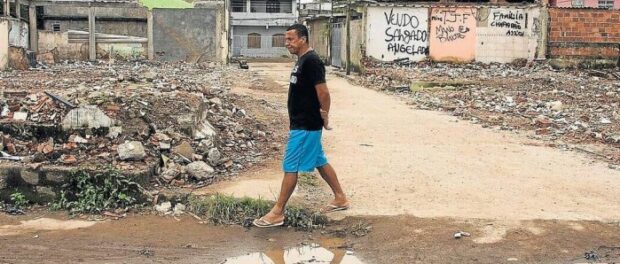 Resident of Vila Autódromo, Luiz Cláudio Silva, walking through the community. Photo by Antônio Scorza / Globo Agency