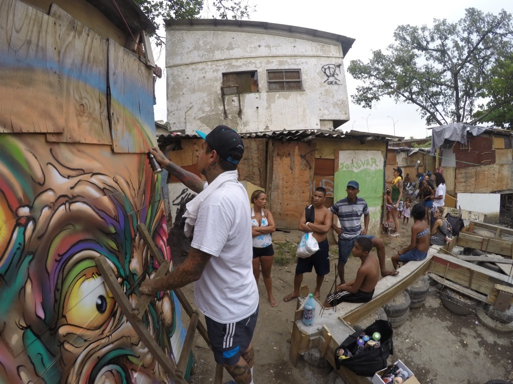 Graffiti artist Bruno Smoky from the Brasilândia favela in São Paulo contributes to artwork in Maré’s newest favela. Photo by Monara Barreto, March 14, 2014.