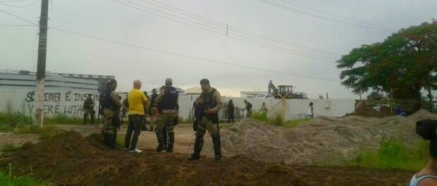 Shock Troops stand guard as the new fence is built. Photo from Vila Autódromo Facebook page