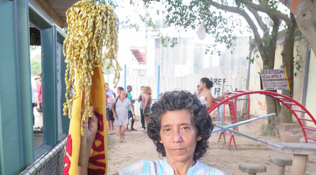 Maria da Penha holding Poverty Torch in the Parquinho before playground demolition