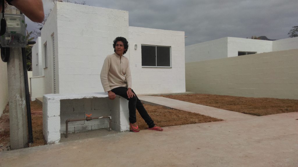 Maria da Penha sits outside her new home