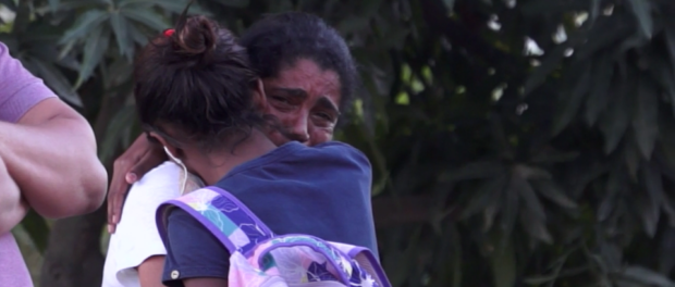 Naomy and her mother hug, crying, as they watch houses in Vila Autódromo being demolished