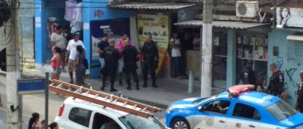 Santiago in pink shirt intimidated by police in Alemão