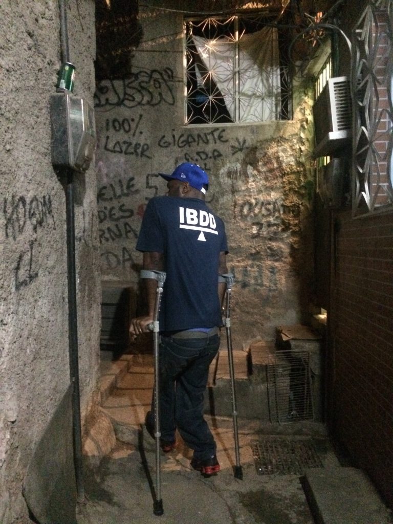 Valdir navigates Rocinha's narrow alleys on crutches