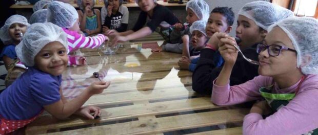 Children take a class on sustainable, healthy, vegetarian cooking hosted at the Favela da Paz kitchen as part of the Vegearte Project.