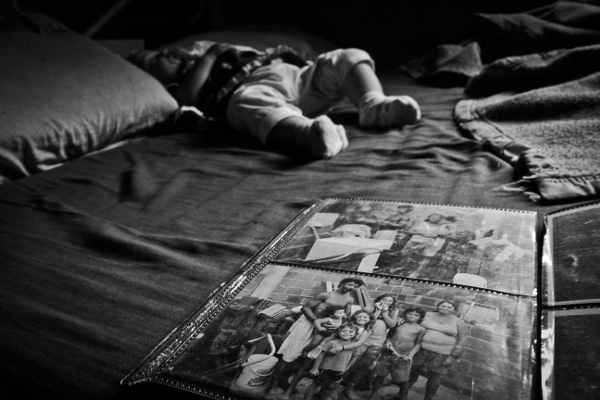 Aline, granddaughter of Dona Evanilde and Senhor Carlos, sleeps in the middle of old family photos