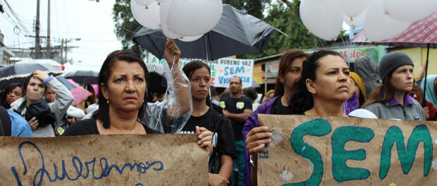 Residents hold signs, ¨We want peace in Maré¨ and ¨No Violence¨. Photo by Carla Shah