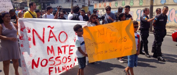 "We don't need assault rifles, we need health and education," reads the sign.