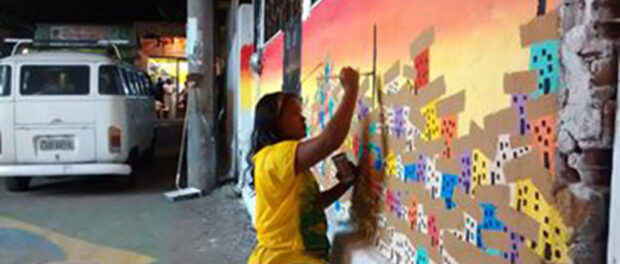 Mariluce Mariá de Souza paints the walls of her community