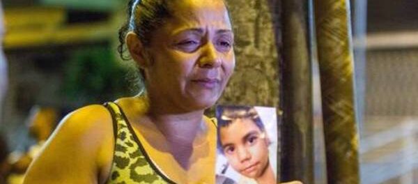 Tereza Maria de Jesus holds a photo of her son, Eduardo, killed by police in March 2015. Photo by Renato Moura