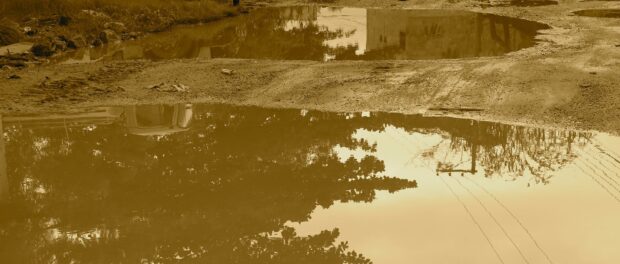 Large puddles on a semi-destroyed street in Vila Autódromo