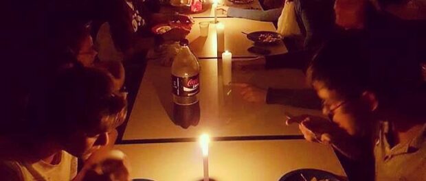 Students at Chico Anysio eat by candlelight after their school's electricity supplies are cut