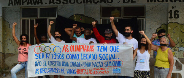 Residents with Olympic social legacy sign before troops arrive to demolish Neighborhood Association. Photo by Meg Healy