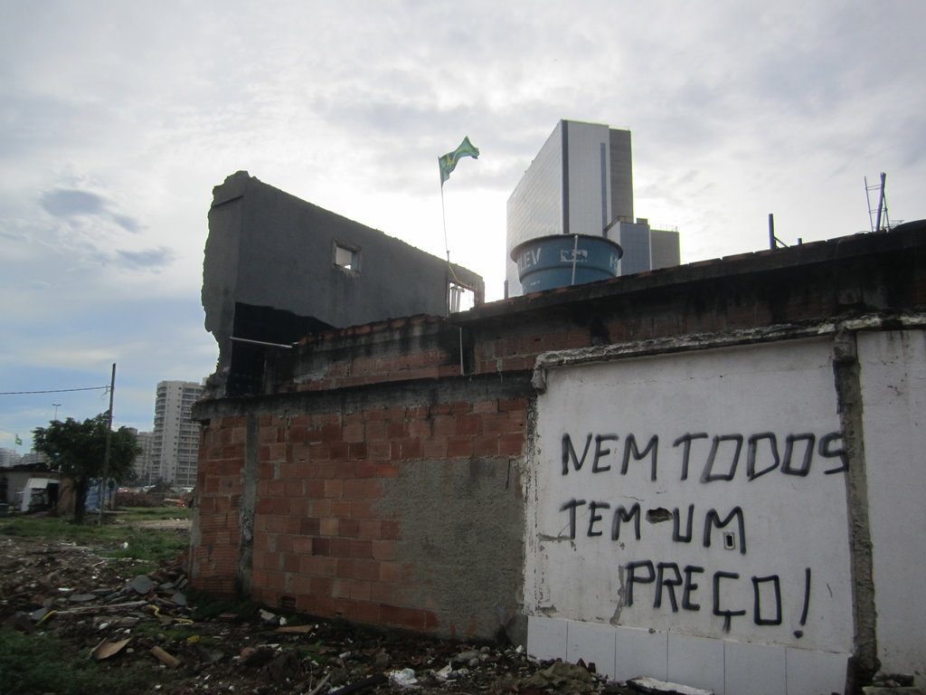 Demolished buildings in Vila Autódromo against Olympic hotel construction in the background