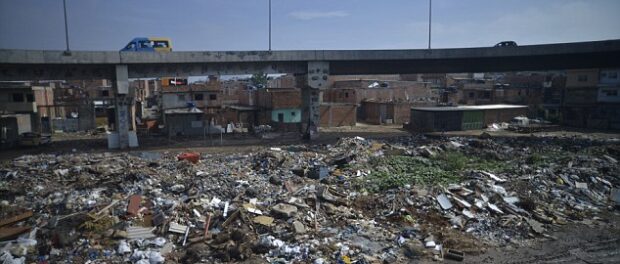 Daily Mail image of a "road passing over a favela" forefronts a heap of garbage.