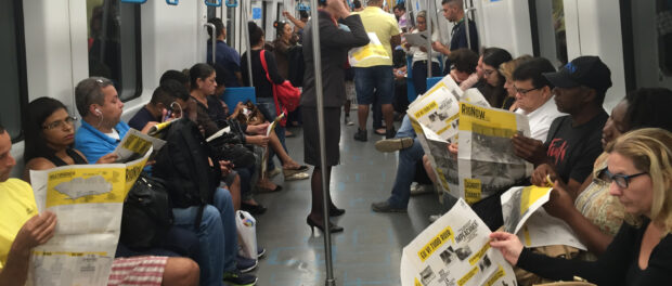 Commuters reading the PUC newspaper