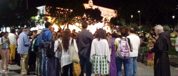 Attendees and religious leaders gather outside of the National History Museum to watch a water-based ceremony