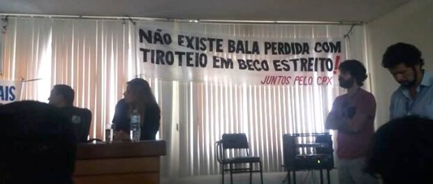 One of the banners brought to the meeting by the Juntos Pelo Complexo (Together for the Complexo) reads "There's no such thing as a stray bullet in a gun fight in a narrow alley!"
