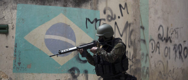 There was a heavy military presence in certain favelas even prior to the 2018 military intervention. Here, a soldier takes aim during an operation in Barbante favela on Ilha do Governador, in Rio's North Zone, in November 2017. Photo: Leo Correa / AFP / Getty Images