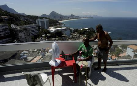 William de Paula and his father on their roof in Vidigal. Photo: Gabriel de Paiva / Agência O Globo