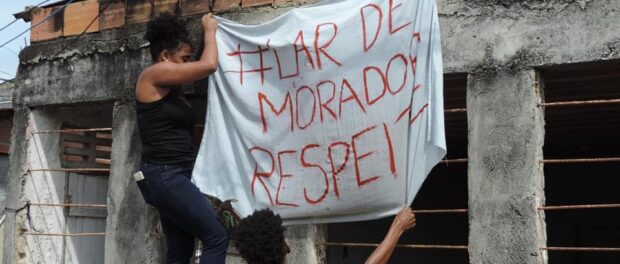 Resident and Alessandro hang the banner “#Resident’s Home Respect”. Photo by Gabriel Horsth