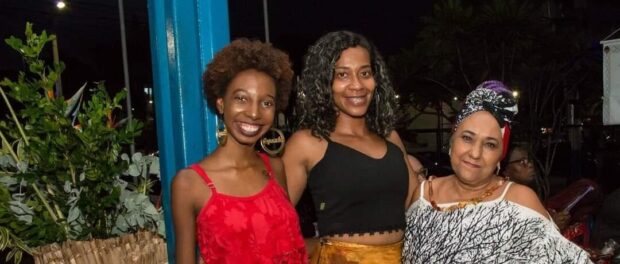 From left to right, Evelyn Pinheiro, Barbara Souza and wearing a blue turban Iya Lucia de Oxum founder of Mulheres Yeopondá. Photo by: Cris Roque and Flávio Carvalho.