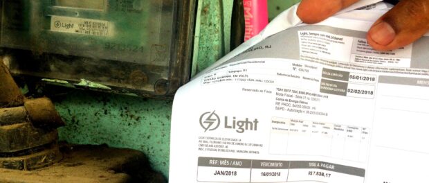 Bar owner shows far overpriced electricity bill in Rio das Pedras, a favela in Rio's West Zone, in 2018.